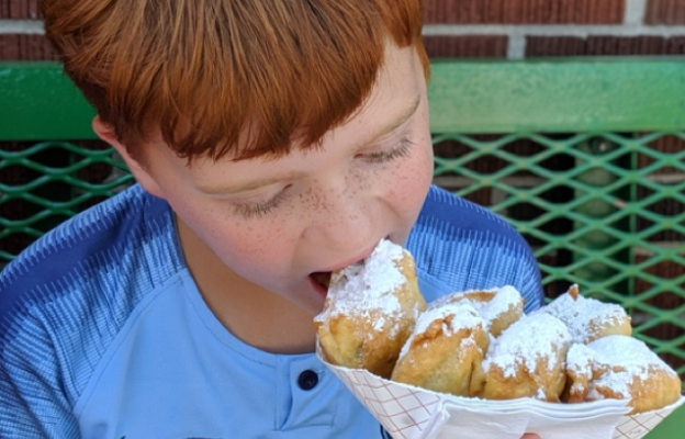 young boy enjoys fried food at the kansas state fair in hutchinson kansas