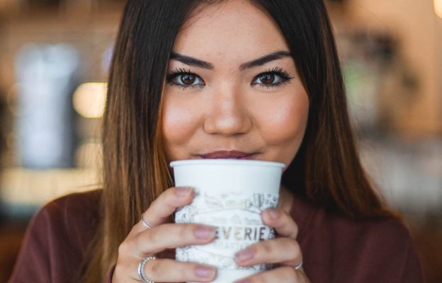 girl posing with reverie roasters coffee cup in wichita kansas