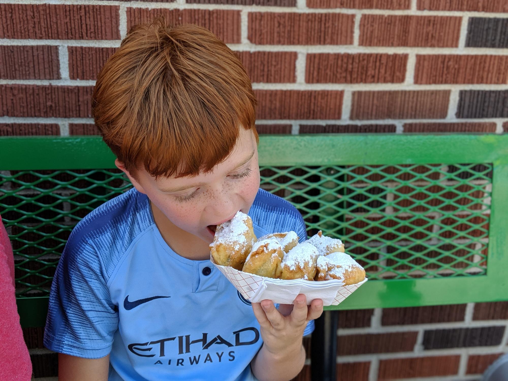 kid eating fried food at the kansas state fair in hutchinson